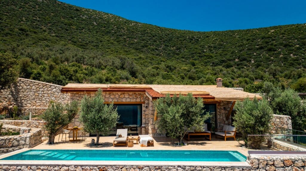 Water’s Edge 4 villa in Kalkan – honey-stone exterior with private pool and olive tree backdrop, a secluded Mediterranean honeymoon retreat.