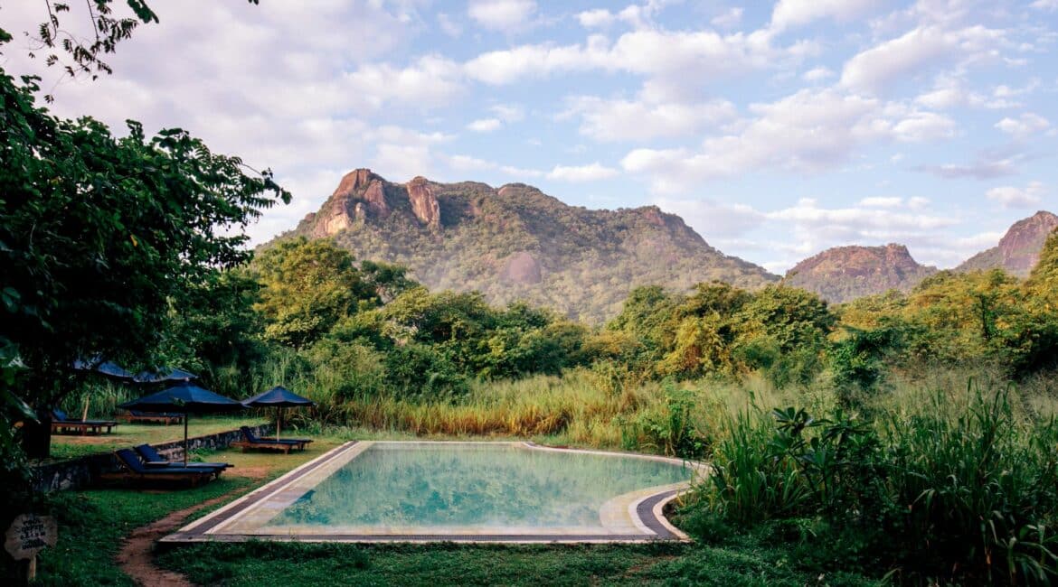 Gal Oya Lodge main swimming pool with panoramic views towards Monkey Mountain, set within lush wilderness of Gal Oya National Park, Sri Lanka.