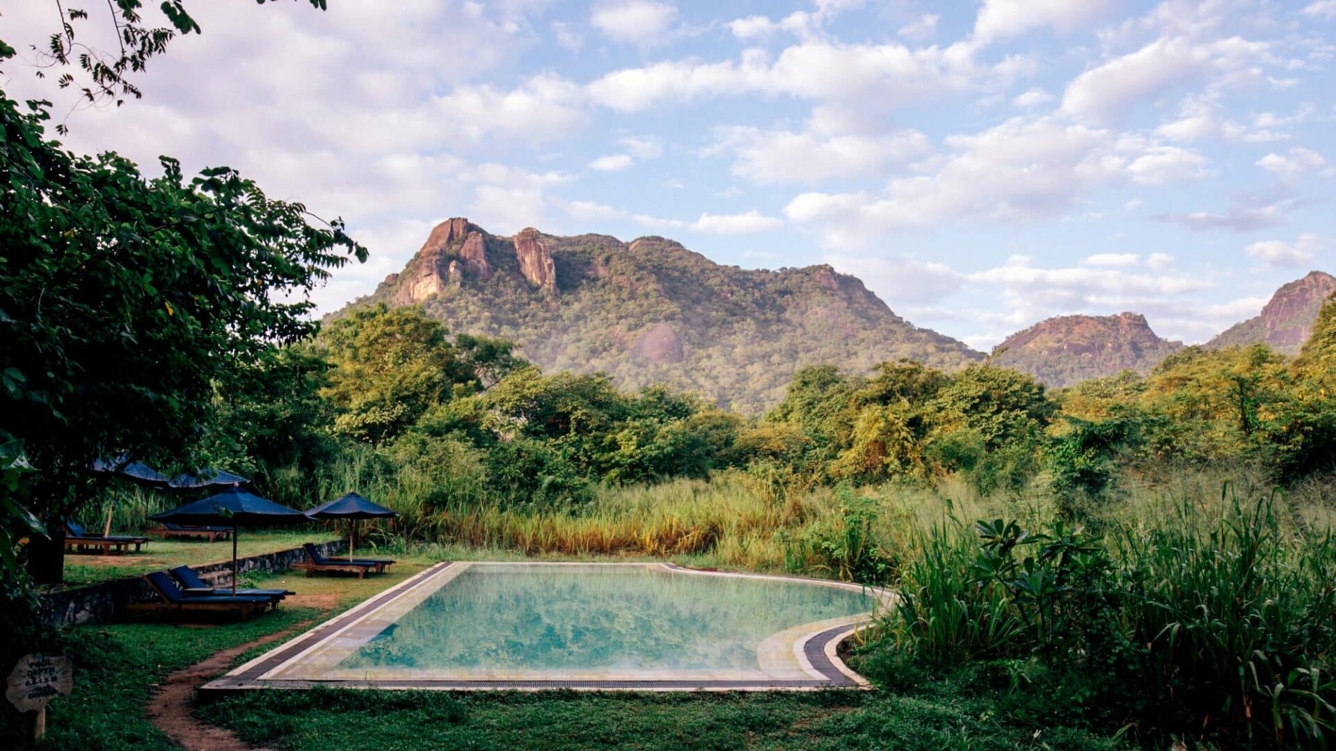 Gal Oya Lodge main swimming pool with panoramic views towards Monkey Mountain, set within lush wilderness of Gal Oya National Park, Sri Lanka.