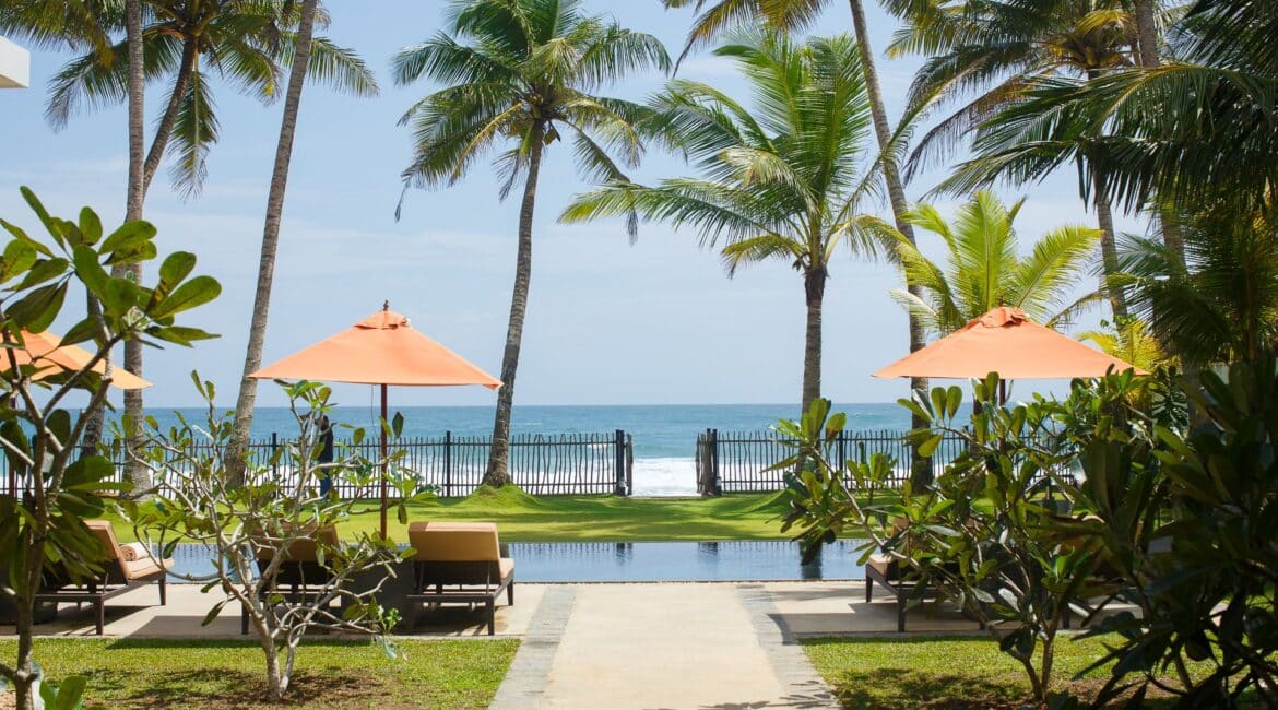 KK Beach Sri Lanka – tranquil setting with a beachfront swimming pool framed by palm trees and golden sand