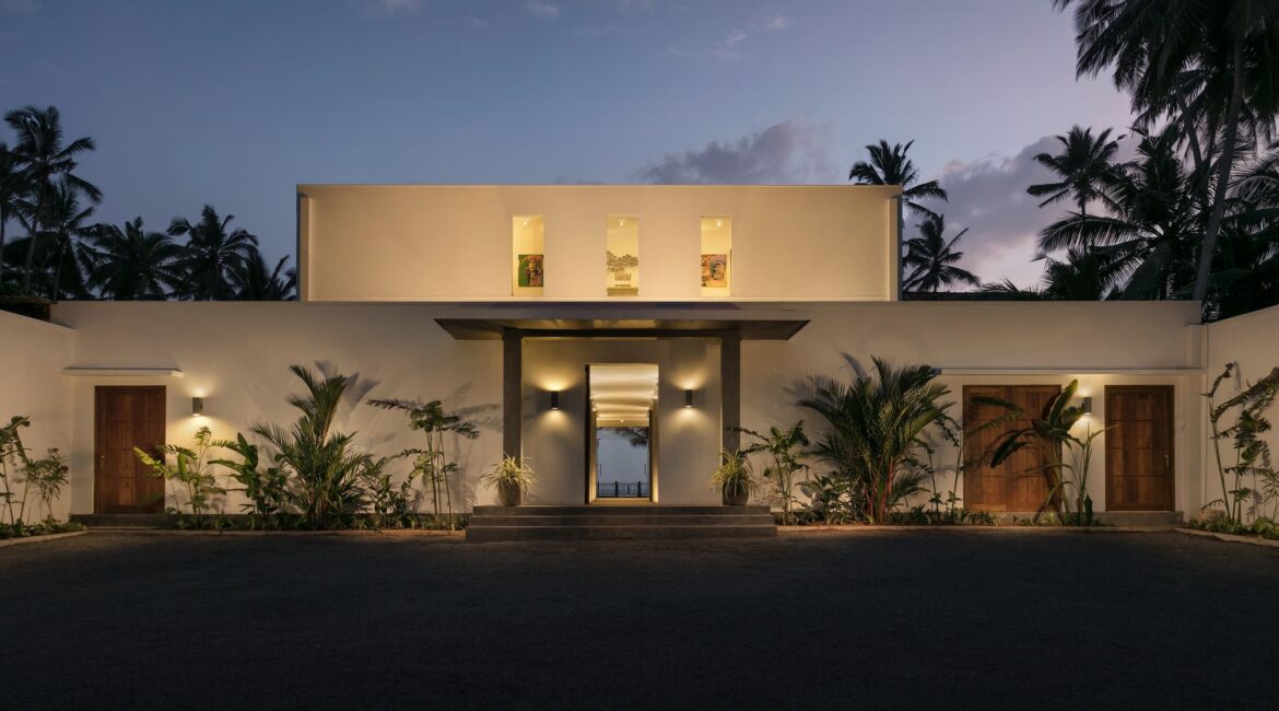 KK Beach Hotel Sri Lanka at dusk – the modern beachfront building softly illuminated against a pink-tinged sky.