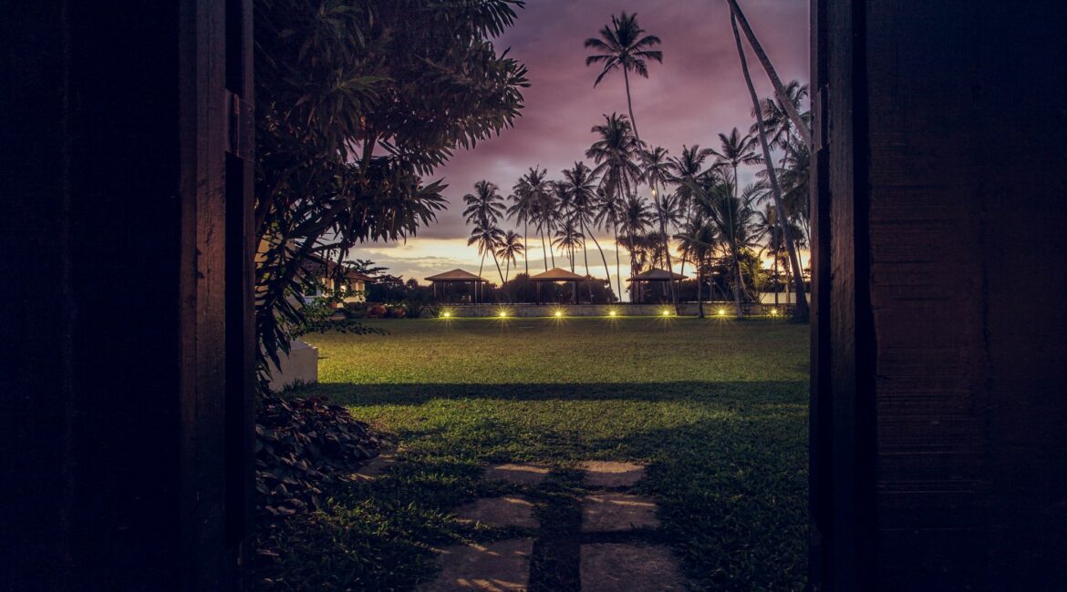 The Villa Bentota lawns under dusty pink skies