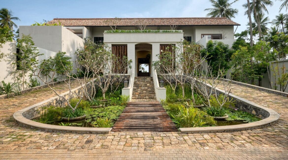 Kayaam House Sri Lanka – elegant hotel entrance framed by tropical greenery and refined architectural details.