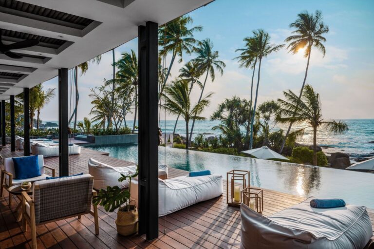 Stunning sunset views over the infinity pool at Ahu Bay Sri Lanka with the ocean and palm trees in the background.