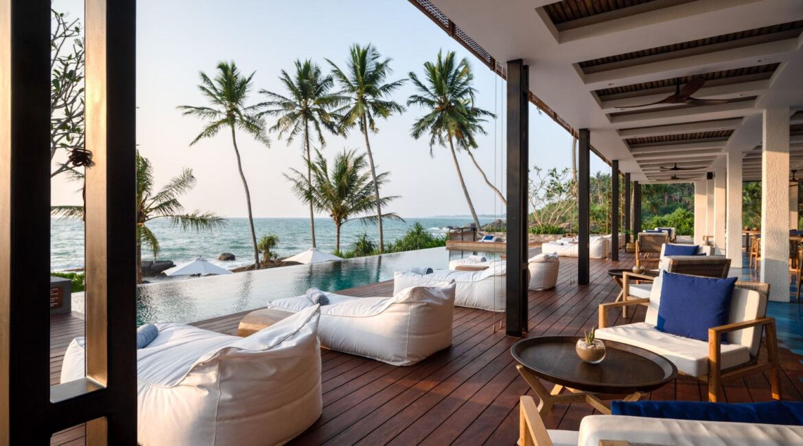 Furnished decks at Ahu Bay Sri Lanka with loungers beside the swimming pool and panoramic sea views.