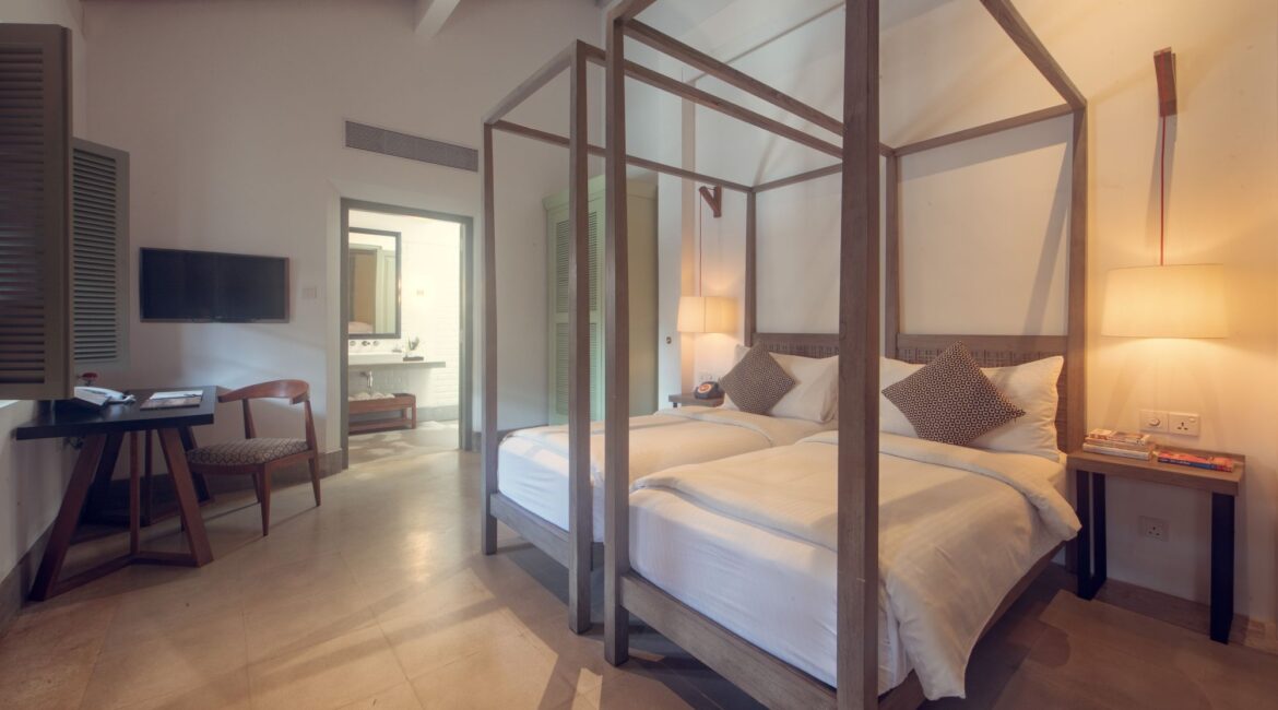 azaar Twin bedroom at Fort Bazaar Hotel Sri Lanka, bright and airy with two single beds, crisp white linens, wooden shutters, and minimal comfortable interiors with simple furnishings.