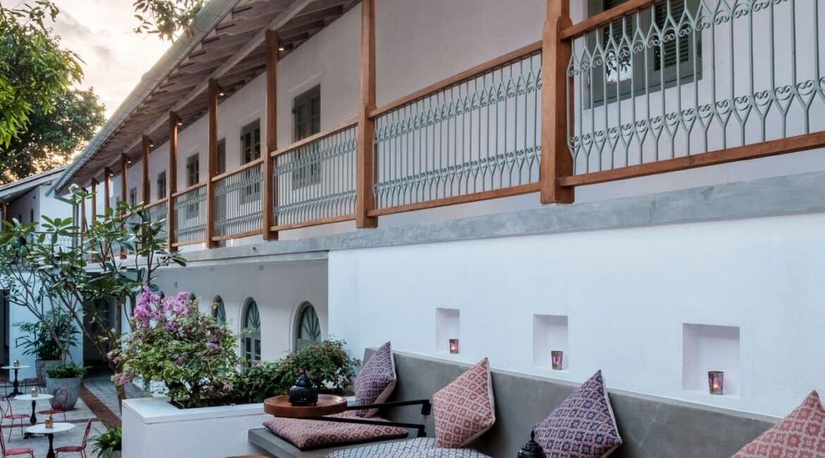 Quiet furnished corner at Fort Bazaar Hotel Sri Lanka featuring a comfortable armchair, side table, and soft lighting in a serene setting.