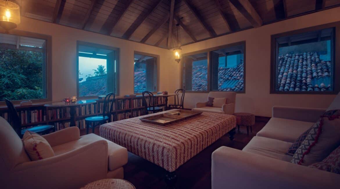 Library at Fort Bazaar Hotel Sri Lanka featuring bookshelves lined with books, comfortable seating, and warm, inviting lighting.