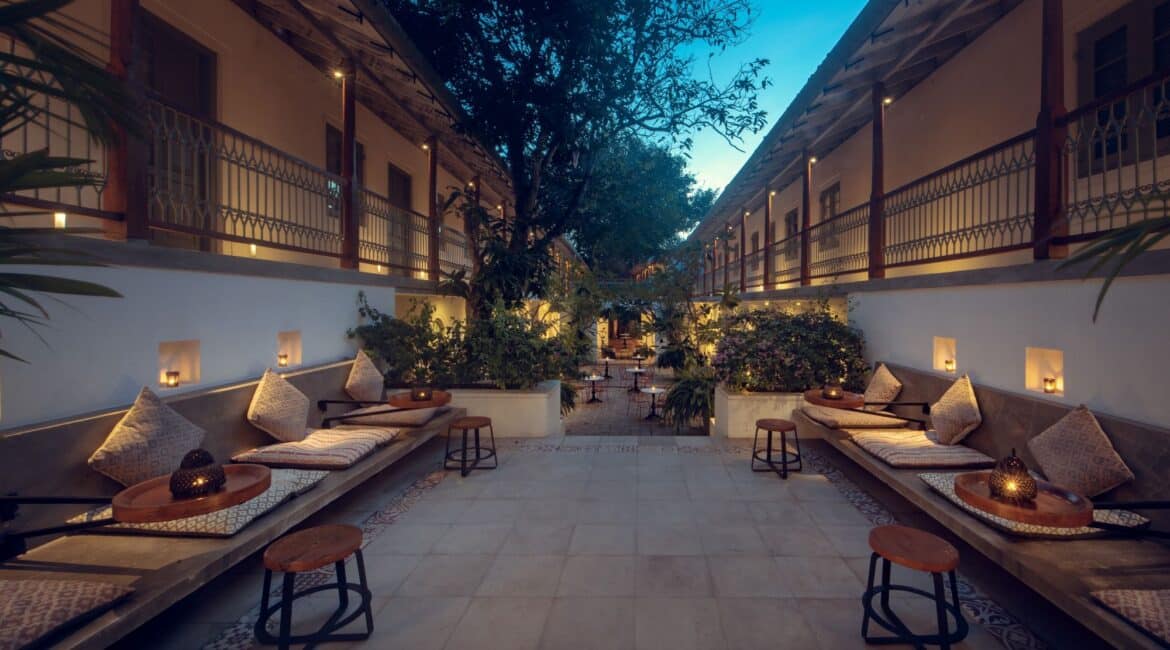 Furnished courtyard at Fort Bazaar Hotel Sri Lanka by night, softly lit with lanterns and surrounded by lush greenery, offering a peaceful, atmospheric space.