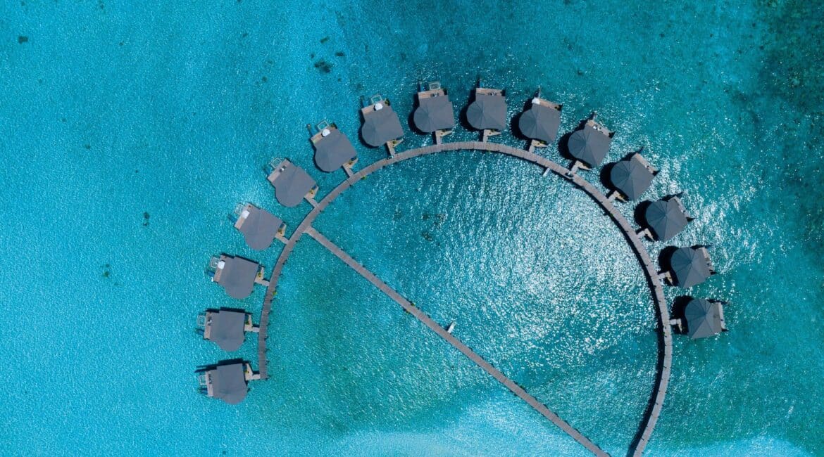 Komandoo Island Resort & Spa once in a lifetime diving experiences shimmering sea with stunning bungalow villas aloft