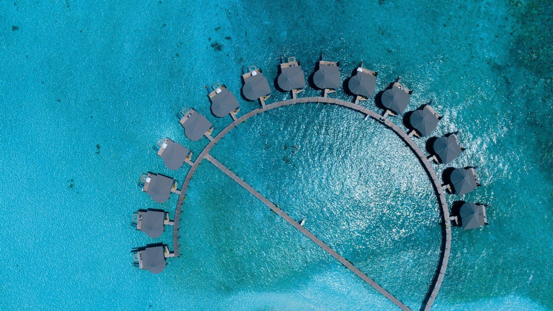 Komandoo Island Resort & Spa once in a lifetime diving experiences shimmering sea with stunning bungalow villas aloft