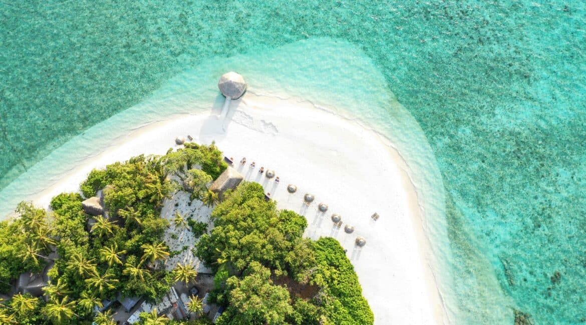 Makunudu Island Maldives drone footage of the multitude of blues and white dusty powder sandy beach below