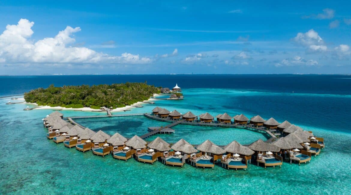 Baros gorgeous pool villas over the Indian Ocean stunning crystal clear sea agaisnt a blue backdrop