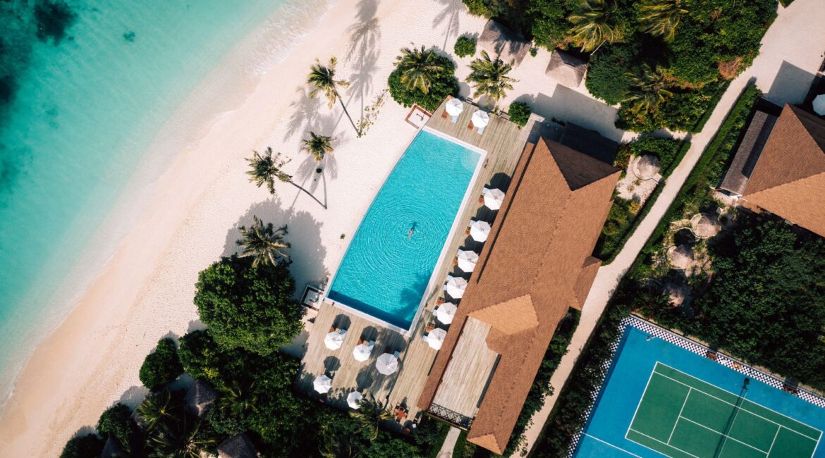 Reethi Faru Resort drone footage of the swimming pool and adjacent beach in the Maldives