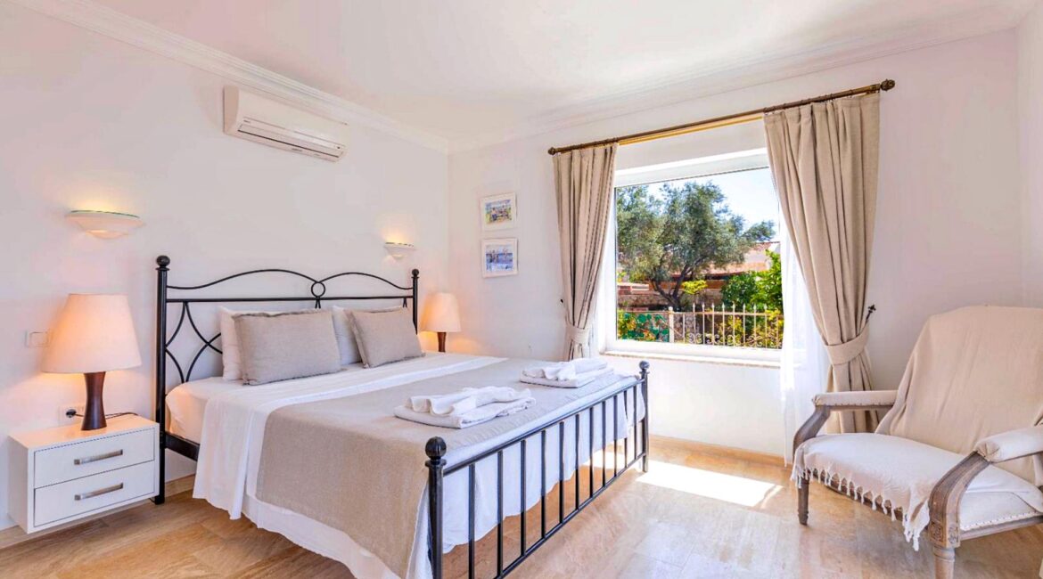 Double bedroom at Villa Bahce Kalkan with balcony doors and sea views.