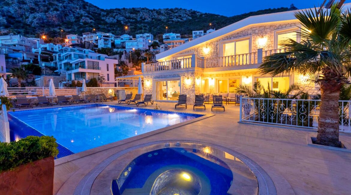 Villa Bahce Kalkan exterior at dusk with private swimming pool, outdoor jacuzzi and illuminated terraces