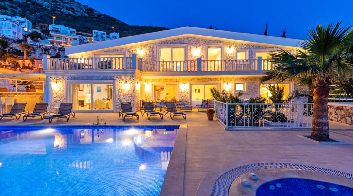 Villa Bahce Kalkan illuminated at dusk with private swimming pool and terrace