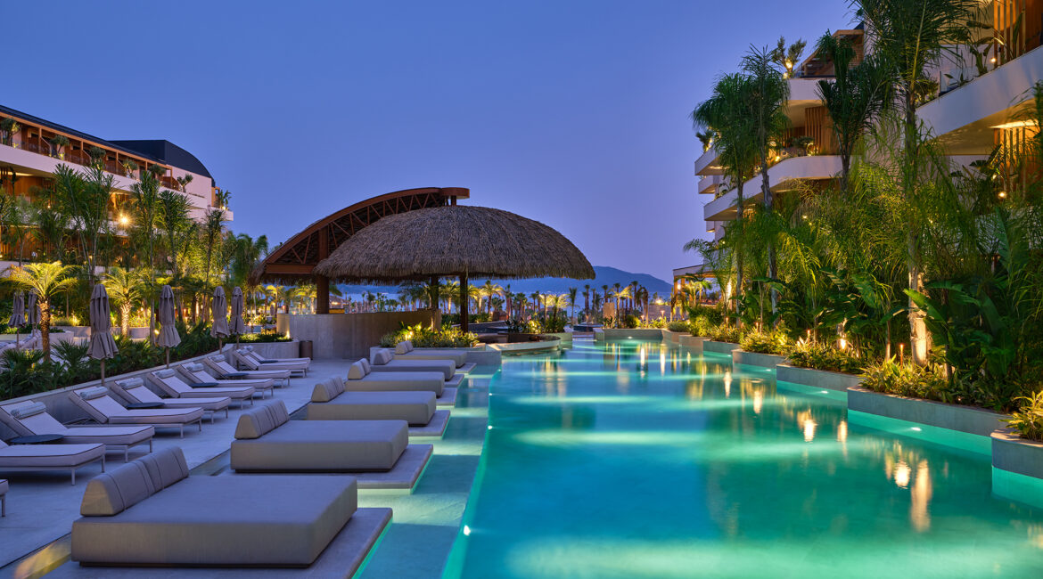 Swimming pool at dusk with sun loungers at XO Cape Arnna luxury resort in Fethiye