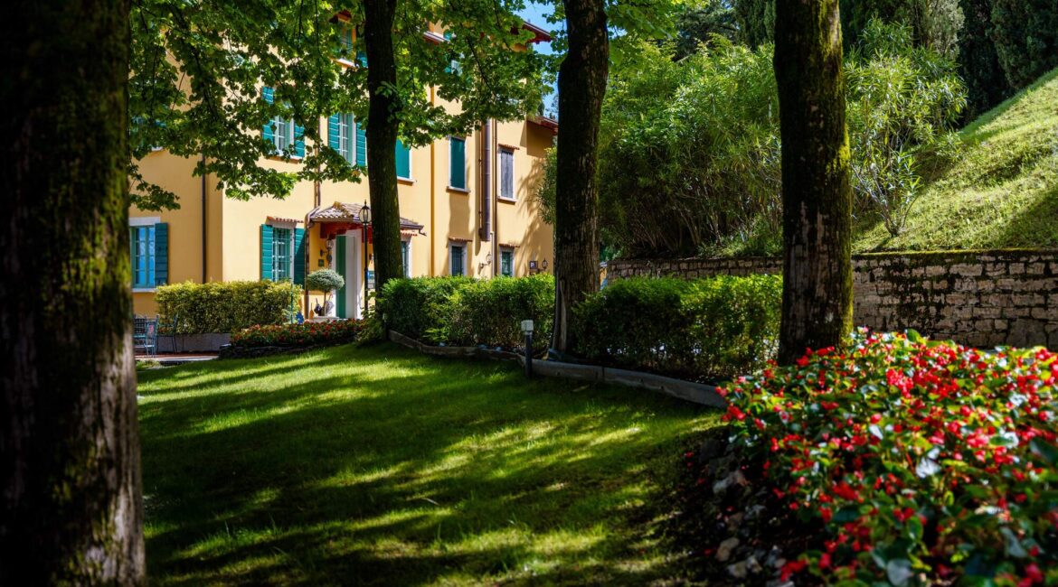 Gardens and terrace of Villa Sostaga surrounded by greenery above Lake Gar