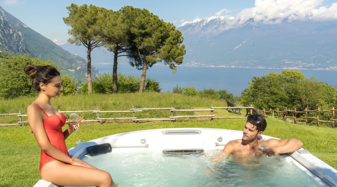 Guests relaxing in the outdoor jacuzzi at Villa Sostaga with Lake Garda views