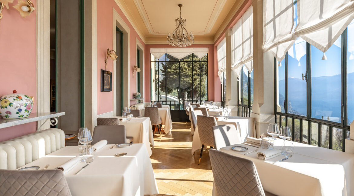 Light filled Dining room at Villa Sostaga with floor-to-ceiling windows overlooking Lake Garda