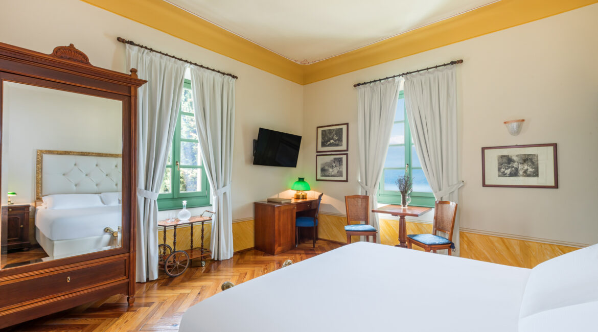 Spacious guest room at Villa Sostaga with wooden floors and lake views