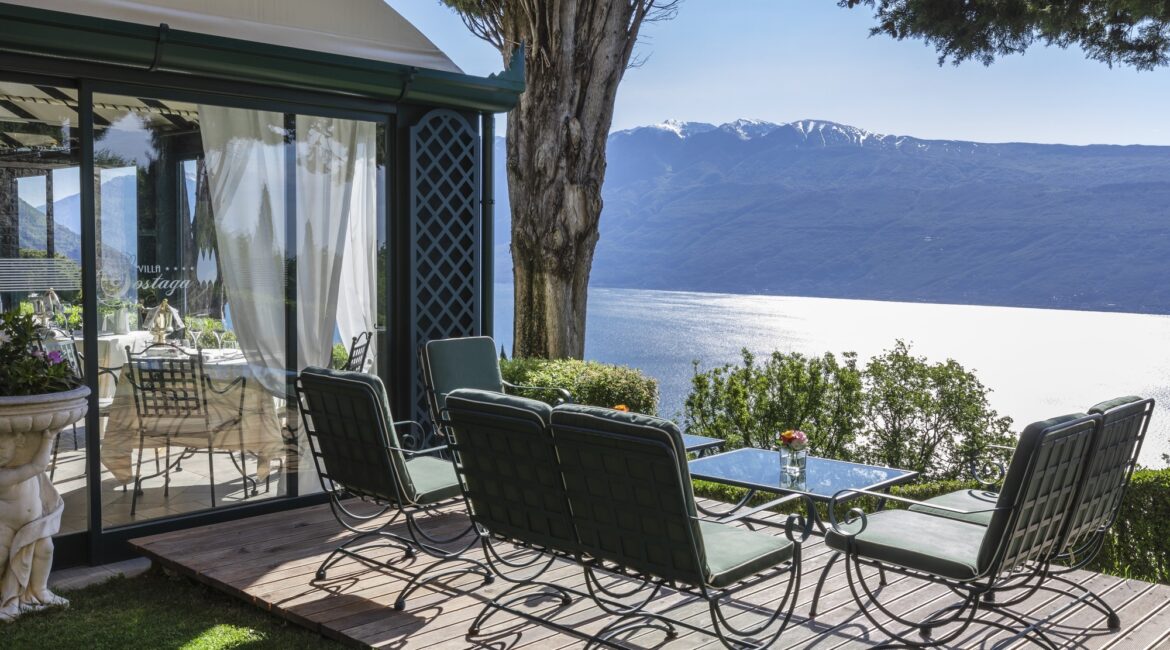 Sun terrace with lounge chairs and mountain views above Lake Garda