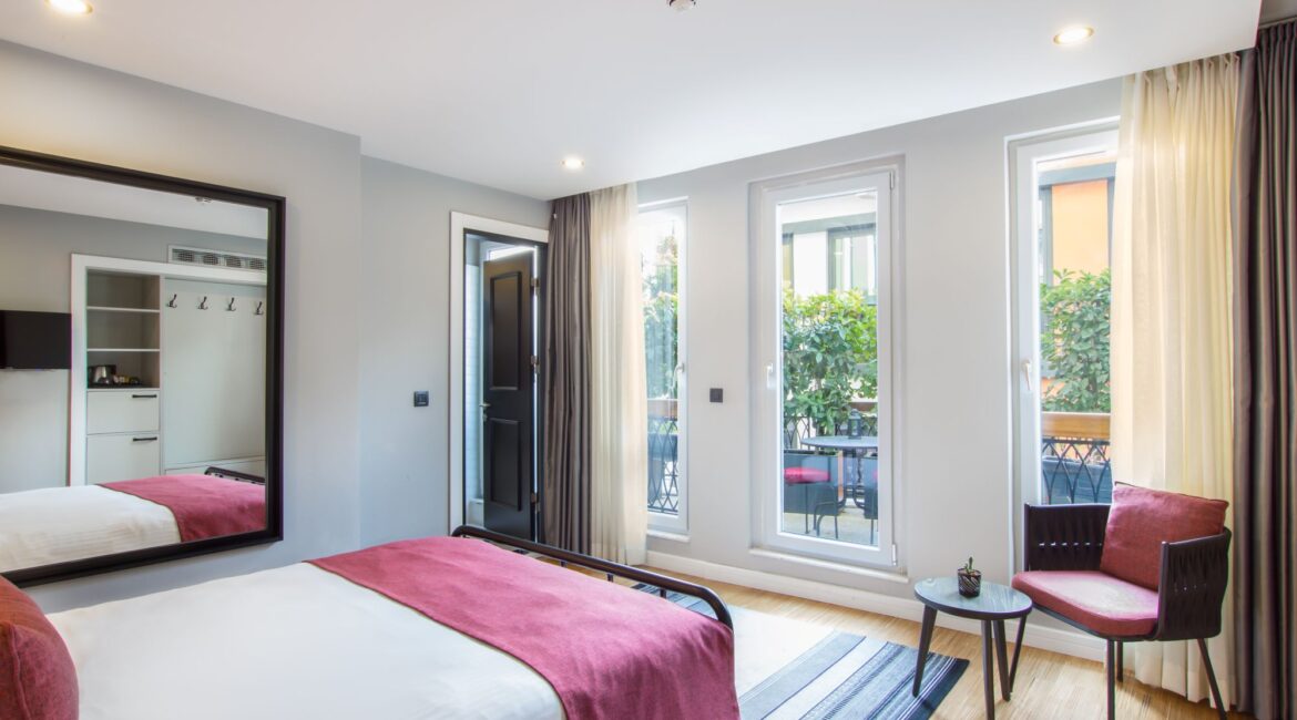 Light-filled premier room with patio at Hotel Poem in Istanbul with floor-to-ceiling doors opening onto outdoor space