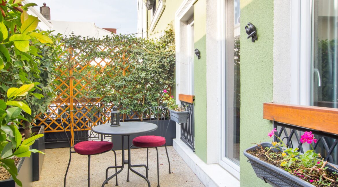 Private patio at Hotel Poem, Sultanahmet, with bistro seating and leafy surroundings