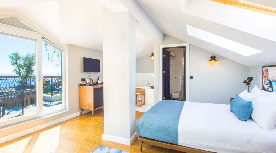 Bright penthouse bedroom at Hotel Poem in Istanbul with large windows and partial sea views