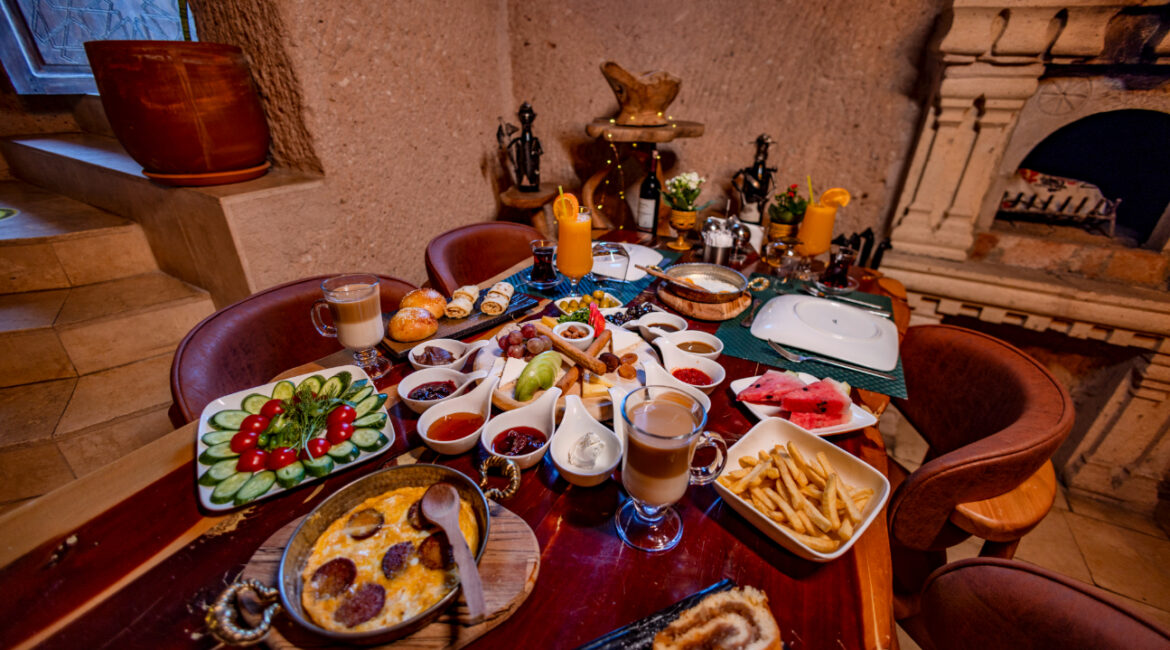 Generous Turkish breakfast table with fresh produce, cheeses, olives and homemade dishes