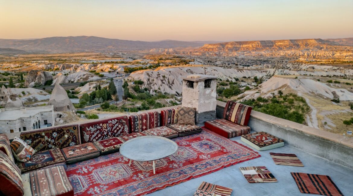 Rooftop kosk seating area with sweeping views across Cappadocia at sunset
