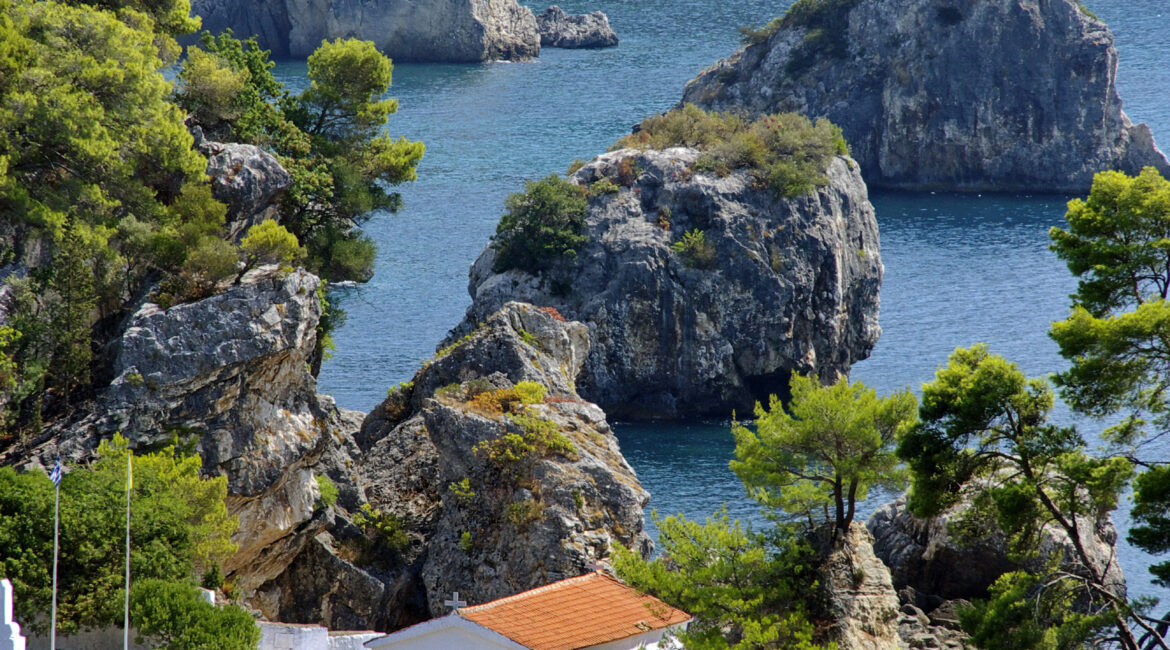 view of the little church of the Assumption on a small island against the pines and the sea of ​​Parga