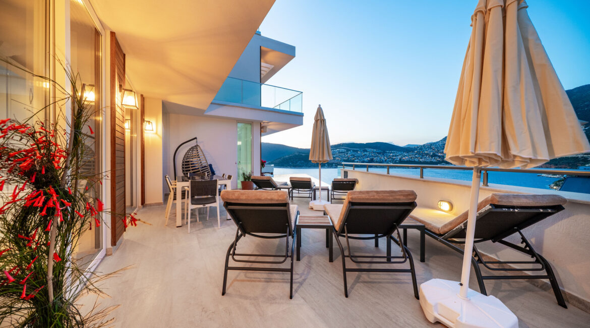 Villa Cennet Koy Kalkan exterior at dusk with illuminated infinity pool and sea views