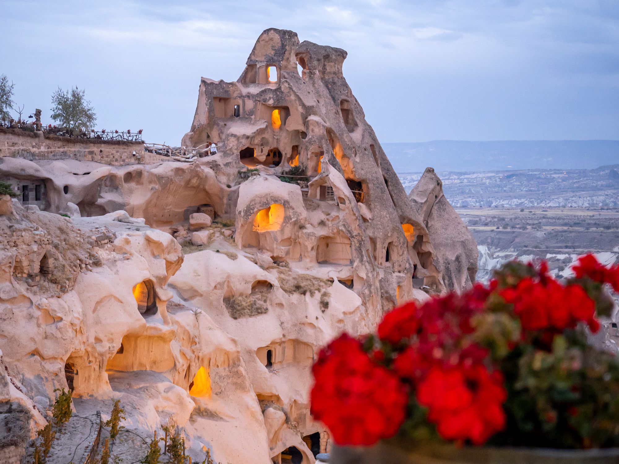 Cave hotel exterior at dusk with warm lighting in Cappadocia