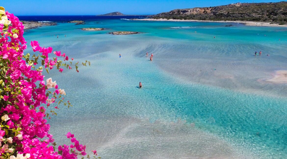 Paleochora beach in Crete with clear turquoise waters and pink bougainvillea