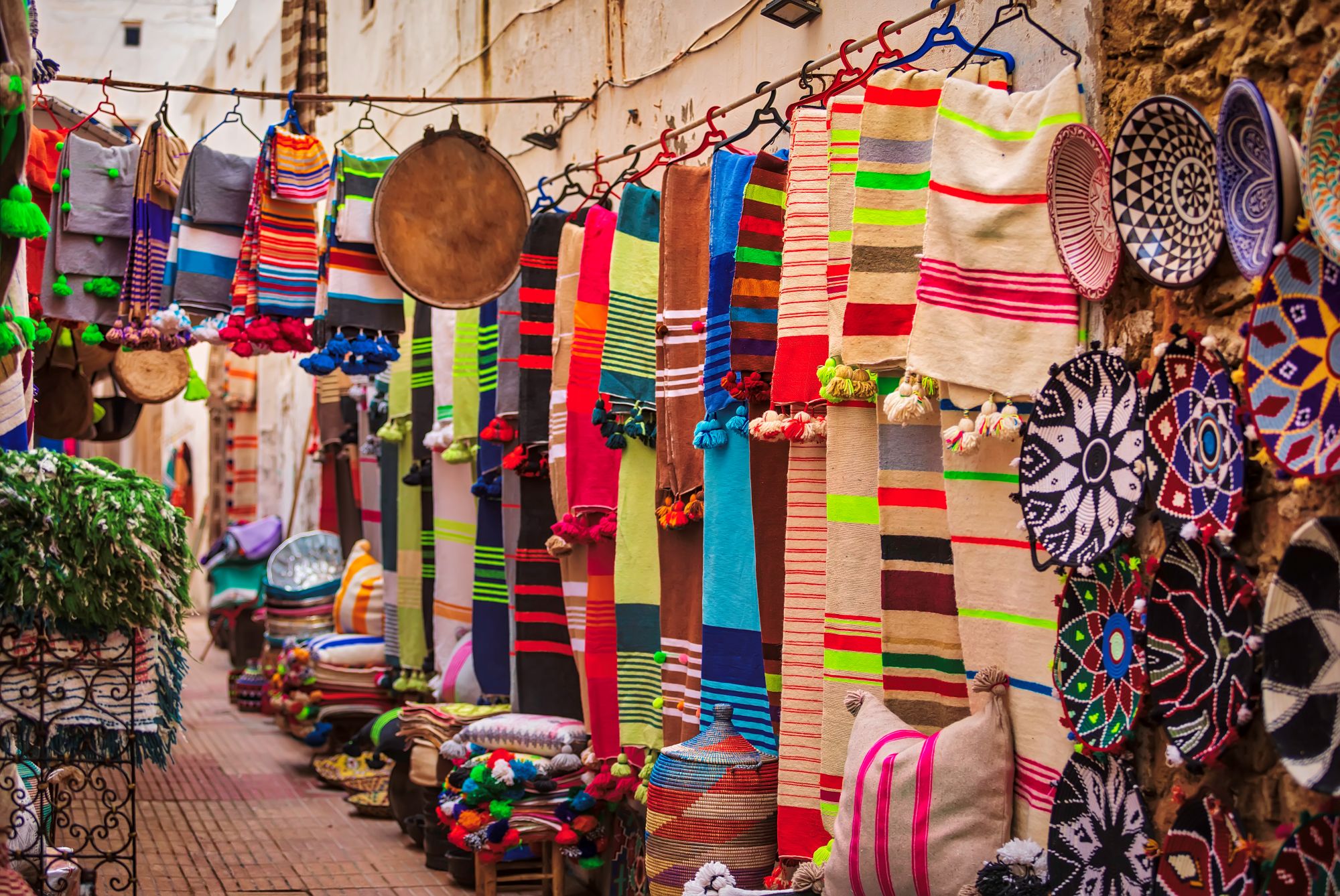 Brightly coloured textiles hanging in an Essaouira souk