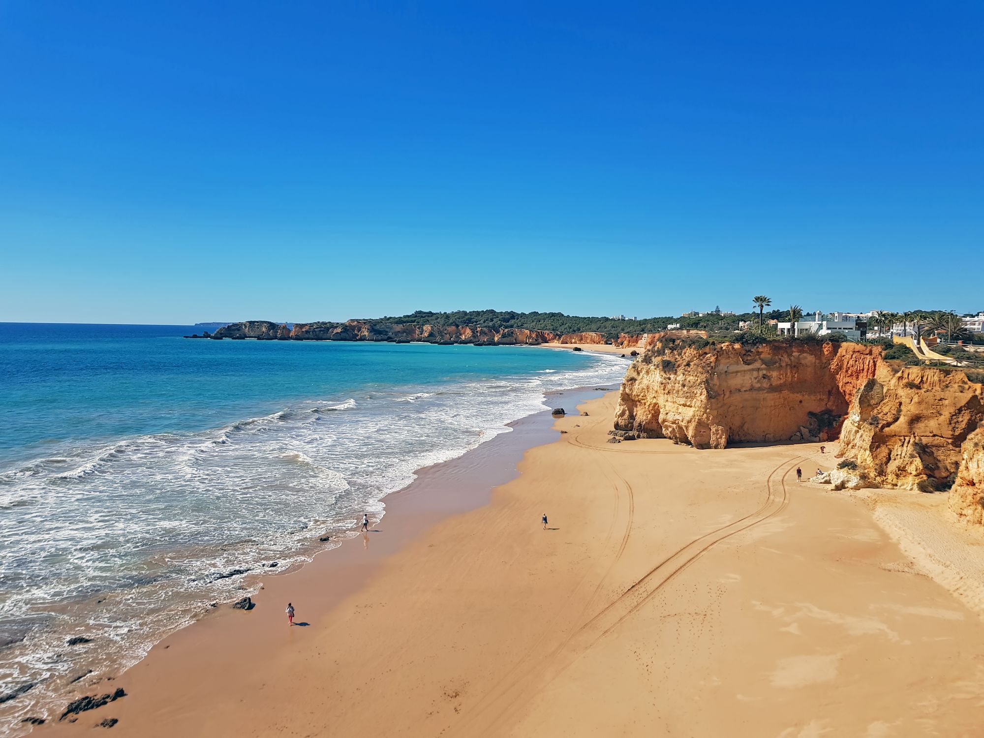 Wide golden beach in the Algarve with clear turquoise Atlantic water