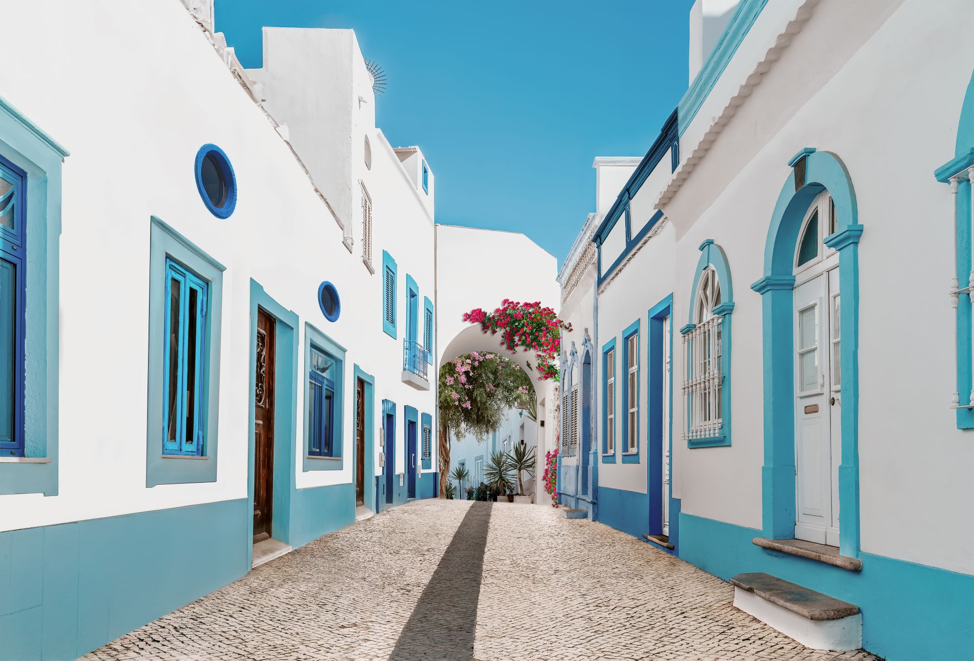 Whitewashed street with blue details in a traditional Algarve town in Portugal