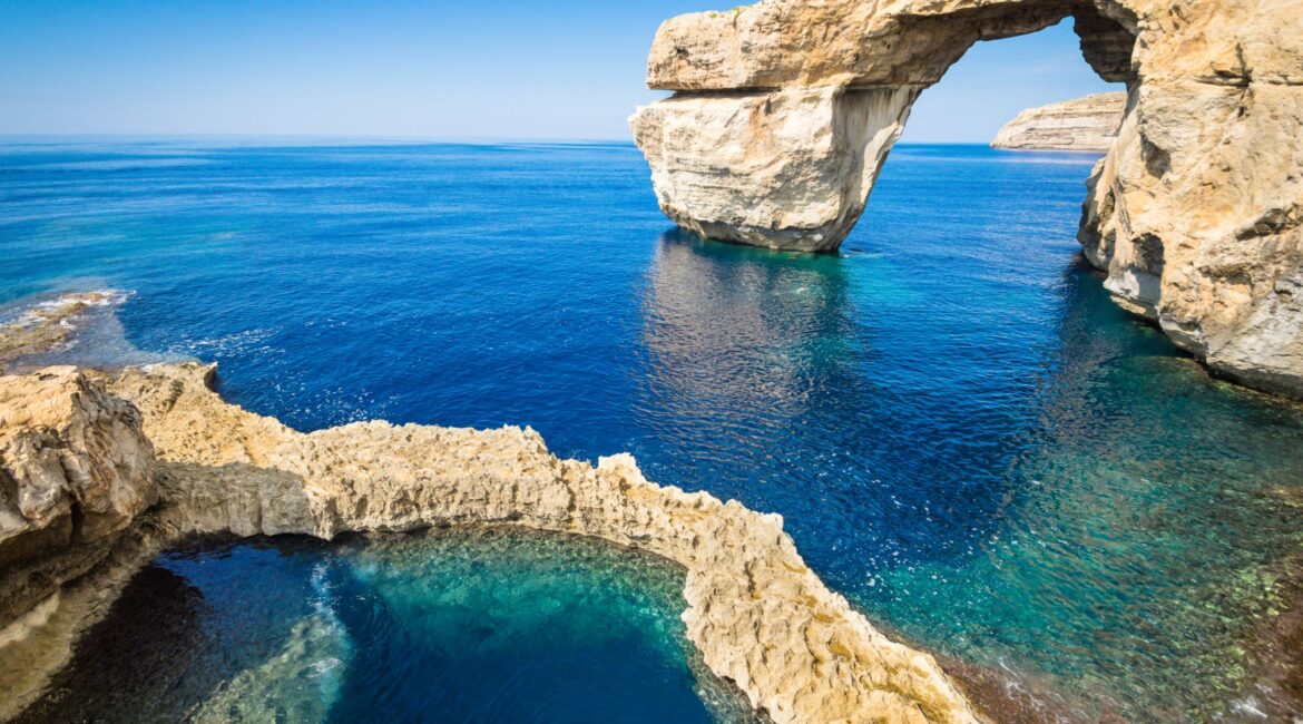 Azure Window rock formation at Dwejra in Gozo with clear blue sea and natural rock pool