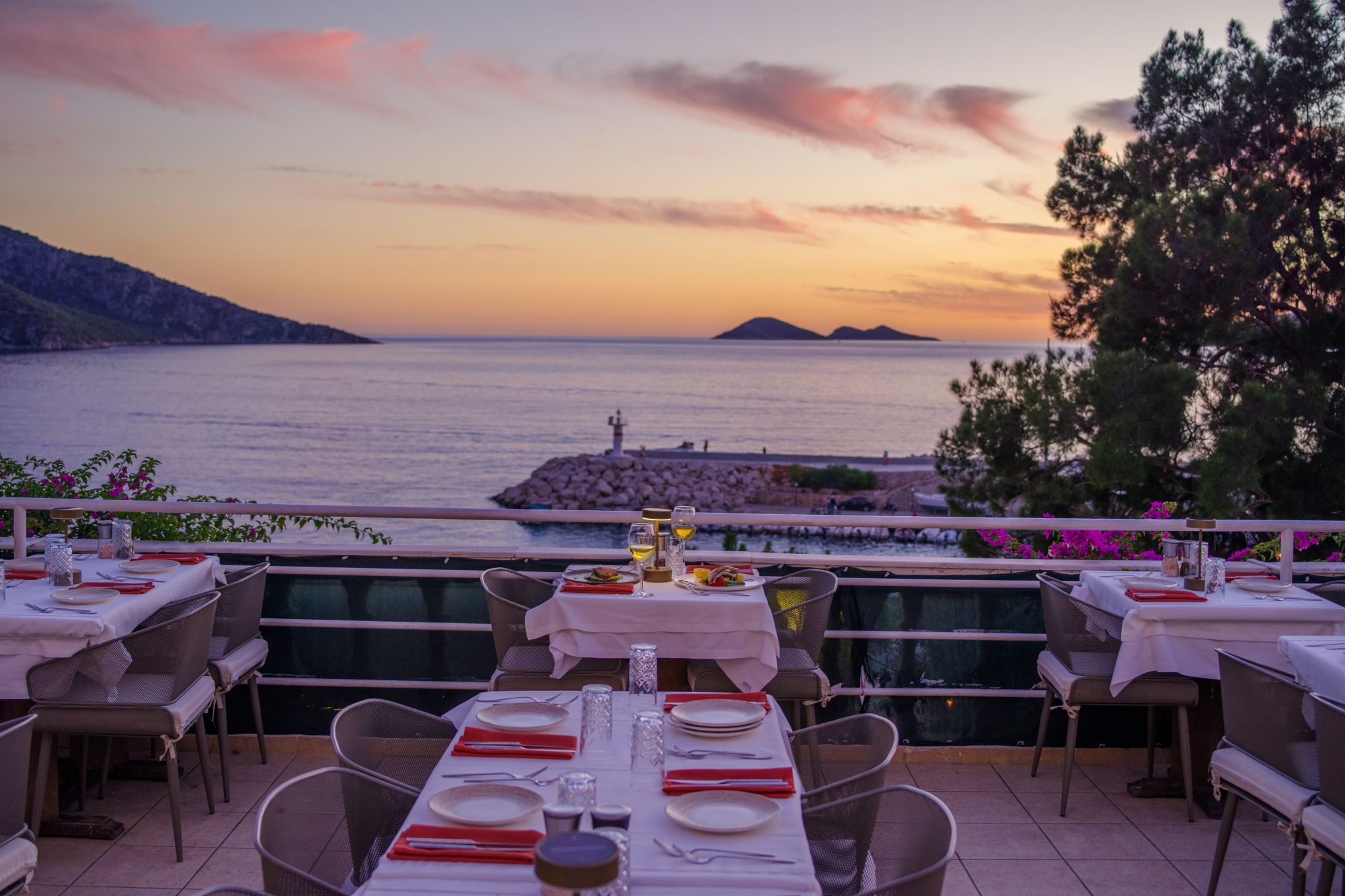 Seafront dining tables at Korsan Fish Terrace overlooking Kalkan harbour at dusk