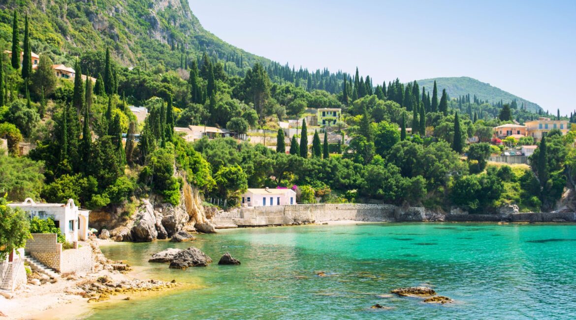 Peaceful turquoise cove surrounded by lush greenery on the Corfu coastline