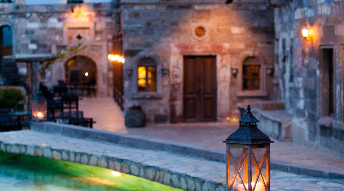 Lantern-lit pool terrace at Museum Hotel Cappadocia at dusk