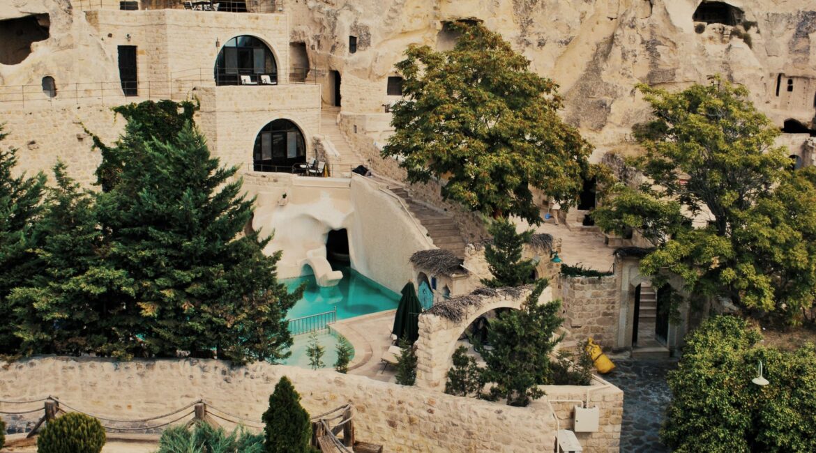 Outdoor swimming pool surrounded by cave dwellings at Yunak Evleri