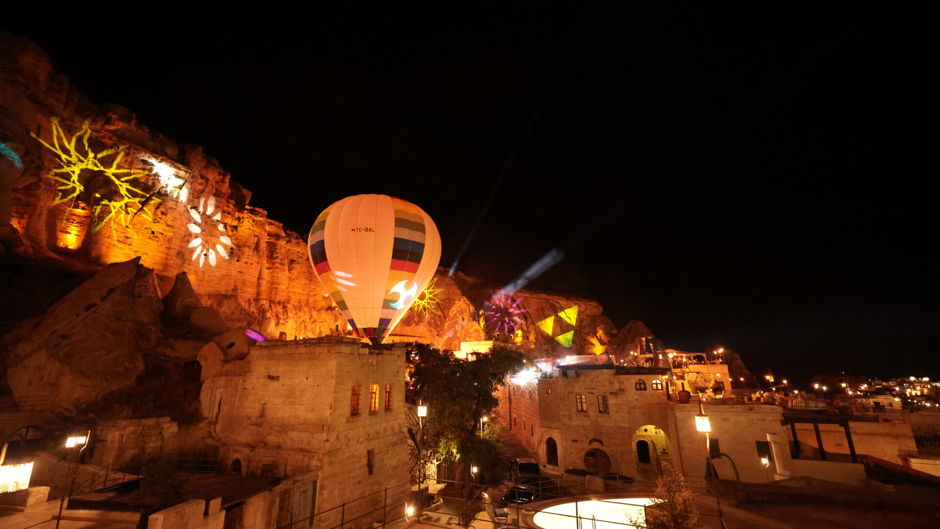Illuminated hot-air balloon above Yunak Evleri Cave Hotel at night in Ürgüp, Cappadocia