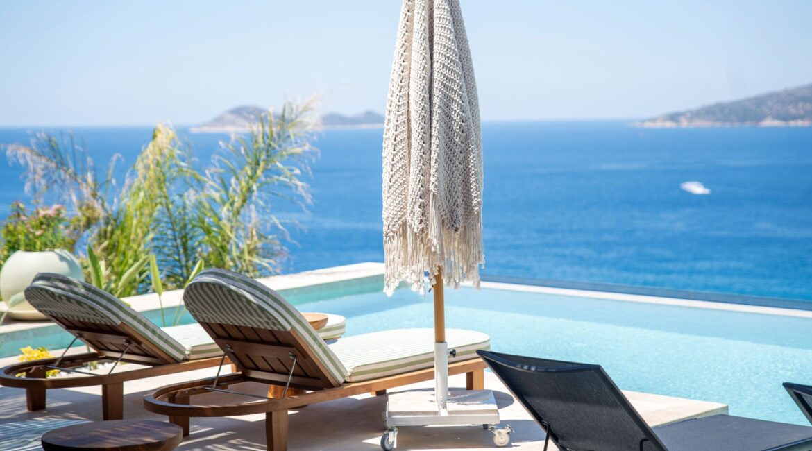 Infinity pool at Casa Pery in Kalkan with luxury sunbeds overlooking the Mediterranean Sea.