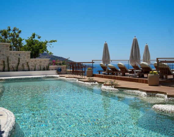 Infinity pool terrace at Casa Pery in Kalkan with sun loungers and sea views.