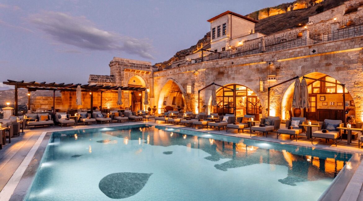 Infinity pool at Kayakapı Premium Caves overlooking Ürgüp, Cappadocia at dusk