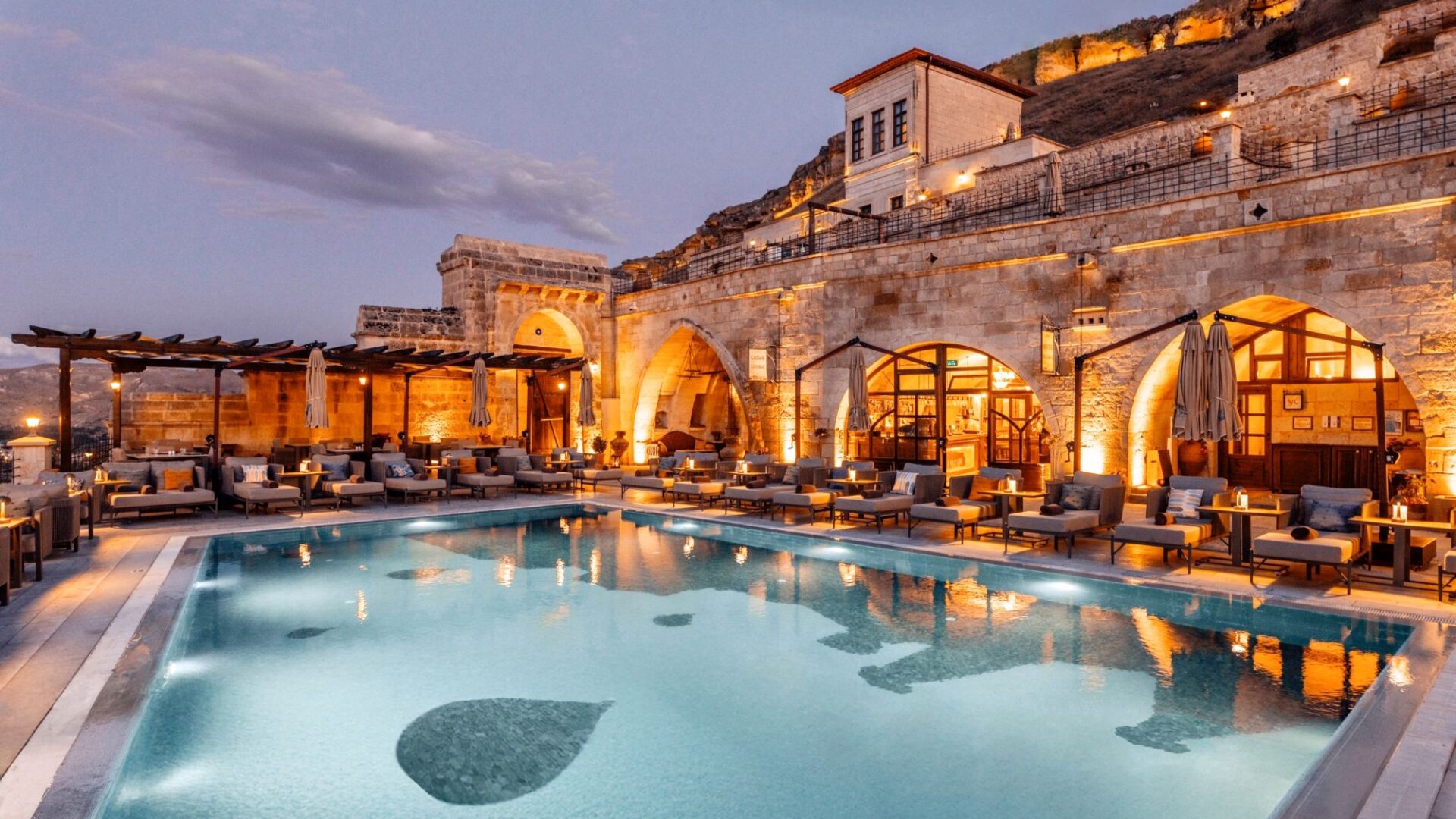 Infinity pool at Kayakapı Premium Caves overlooking Ürgüp, Cappadocia at dusk