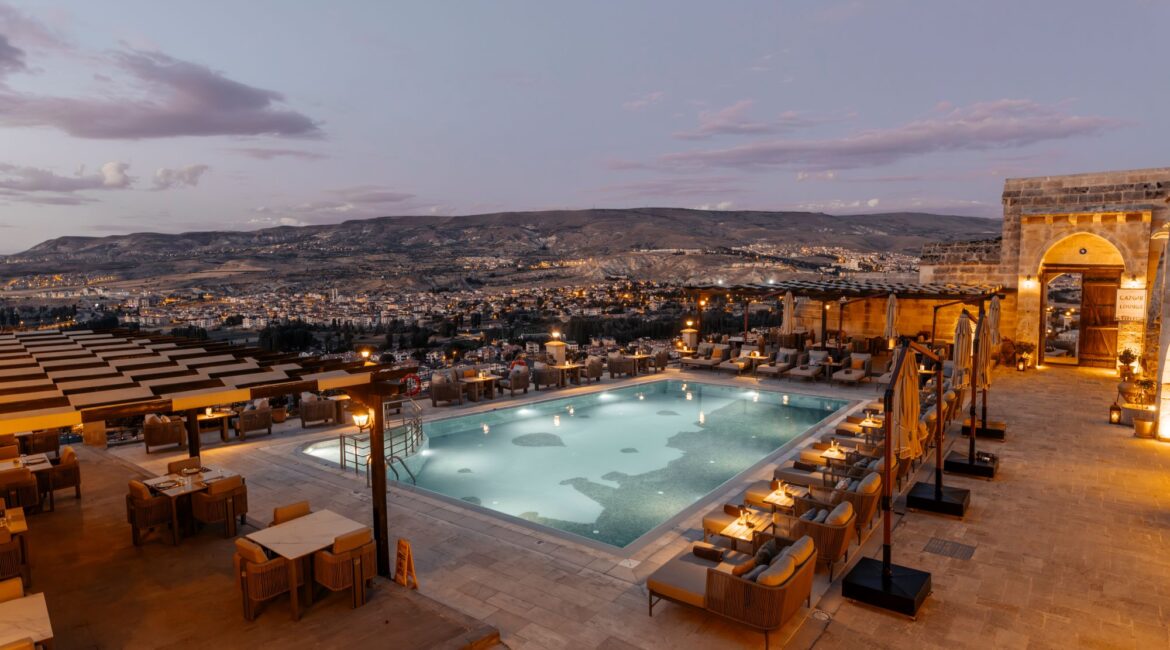 Evening view of the infinity pool and terraces at Kayakapı Premium Caves, Cappadocia
